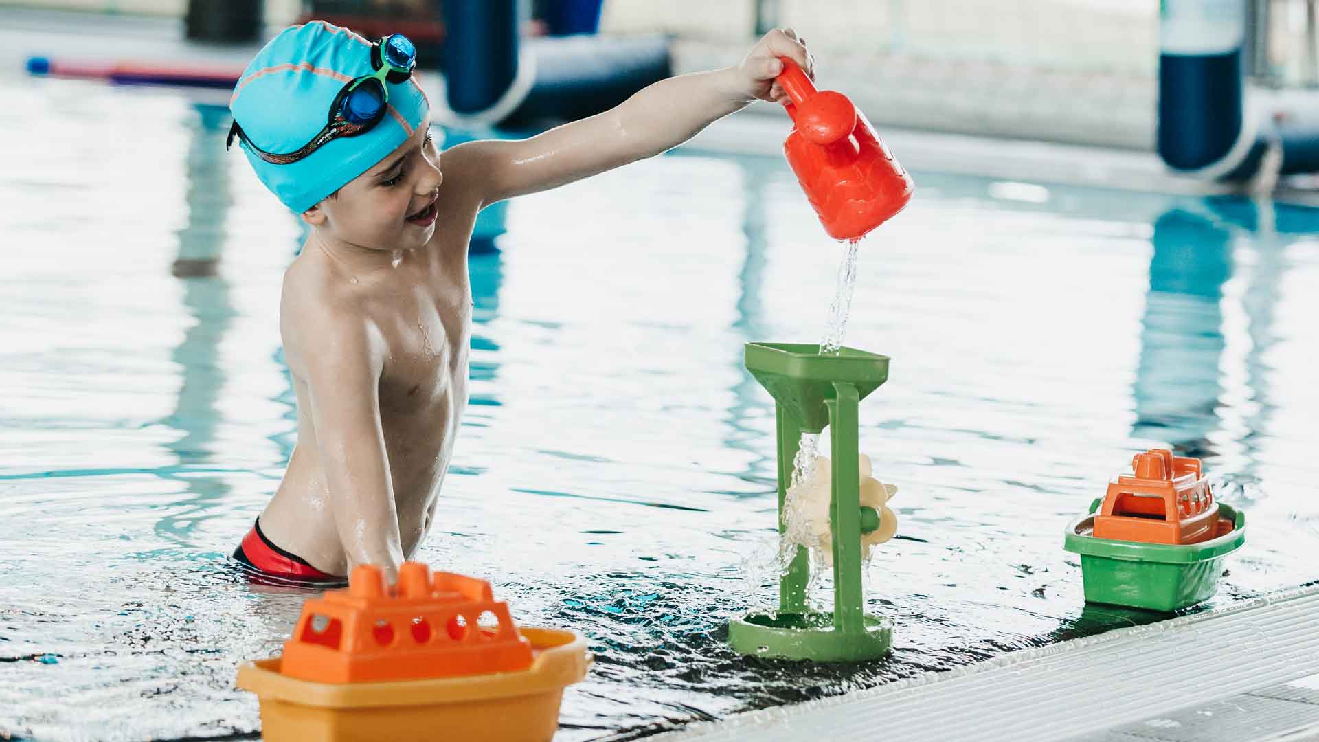 Un enfant joue avec des jouets en plastique dans la piscine.